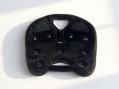 Top view of a black BackJoy ergonomic seat corrector designed to align the pelvis and stop slouching pain.