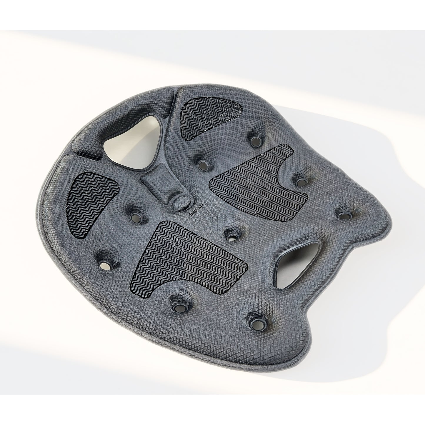 Contoured gray BackJoy ergonomic posture seat engineered to stabilize the pelvis and prevent lower back strain.